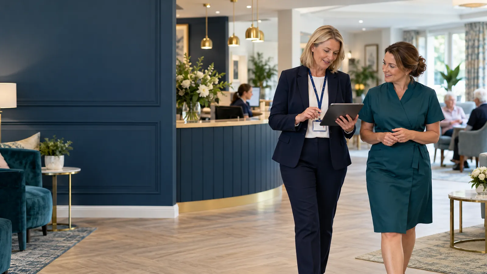 A manager and colleague walking through a care home reception with a tablet