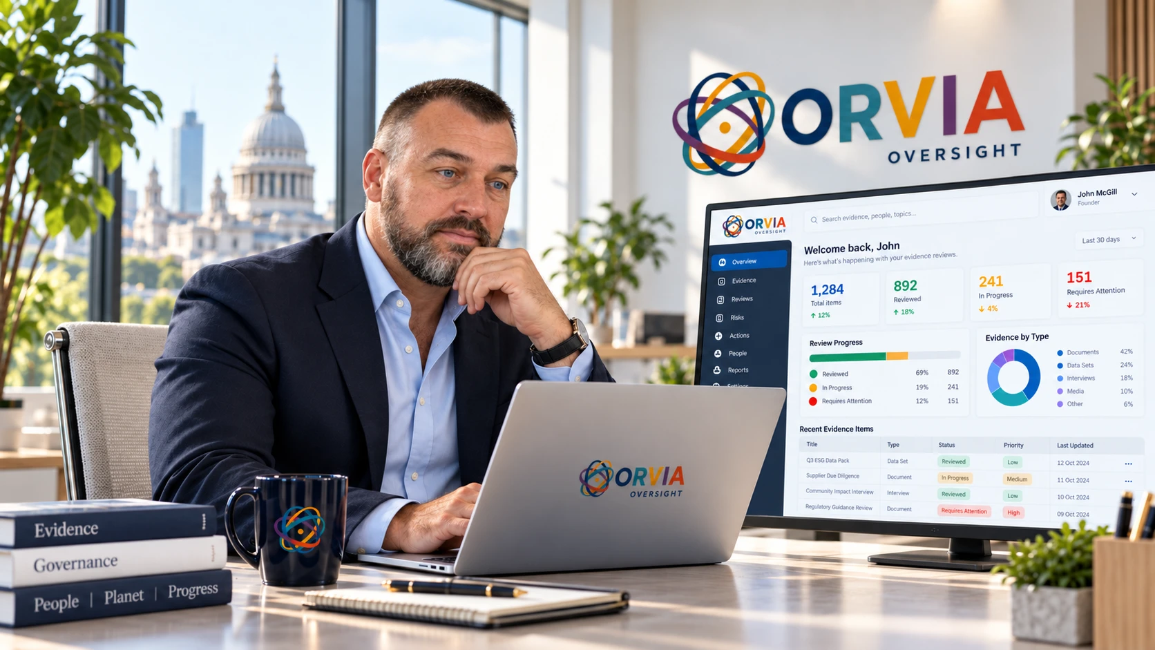 John McGill at a desk alongside an ORVIA workspace illustration